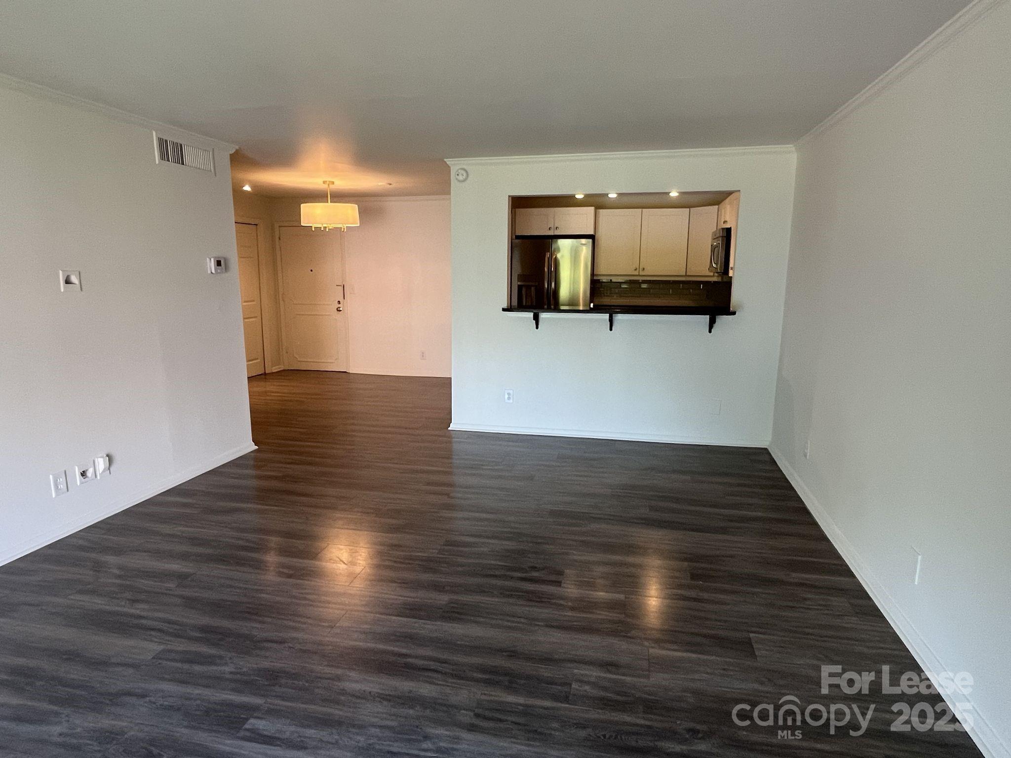 1323 Queens Road, Unit 312 Charlotte, NC 28207 - Photo 9 of 32 a view of a living room with wooden floor and flat screen tv