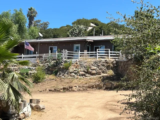 a front view of house with yard and trees in the background