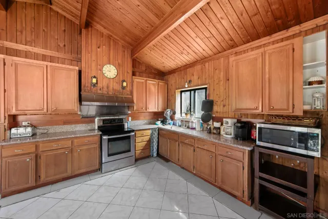 a kitchen with stainless steel appliances granite countertop a stove sink and cabinets