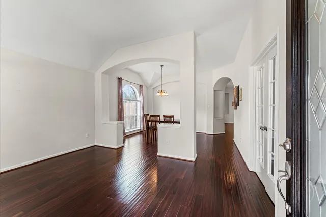 a view of a hallway with wooden floor and staircase