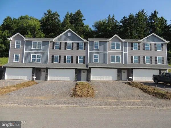 a front view of a residential apartment building with a yard