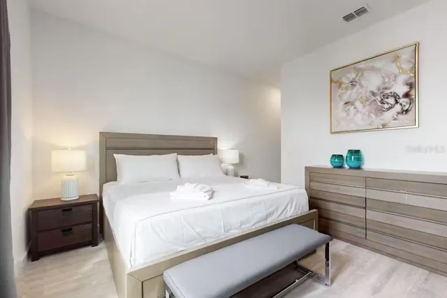 a large white bed sitting in a room next to a window