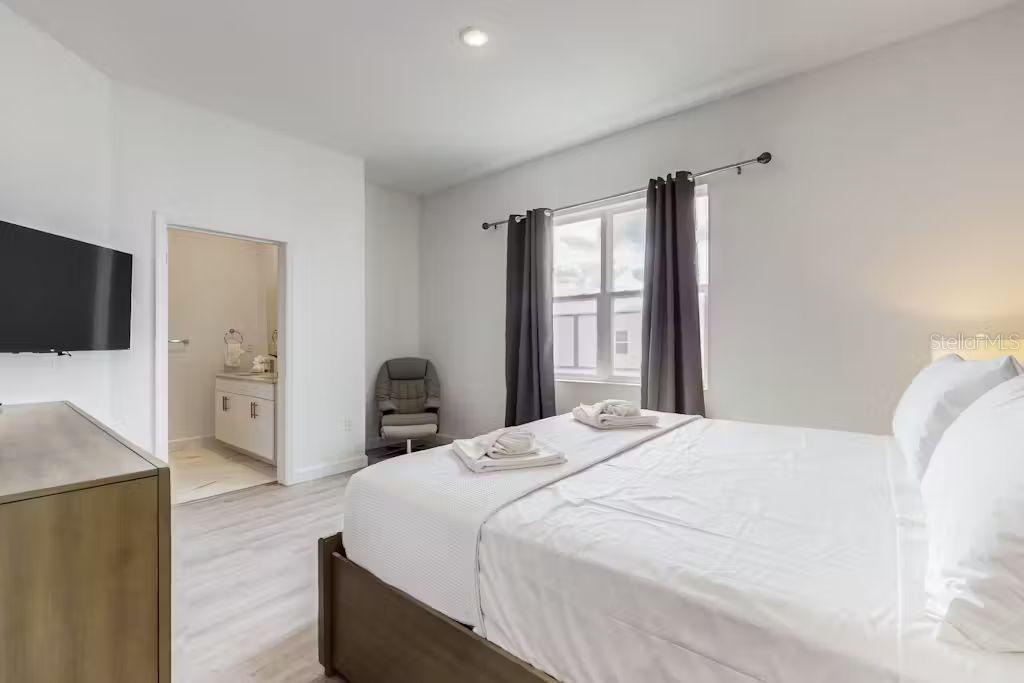 372 Famagusta Drive Davenport, FL 33896 - Photo 17 of 38 a bedroom with a bed and a flat tv screen on dresser