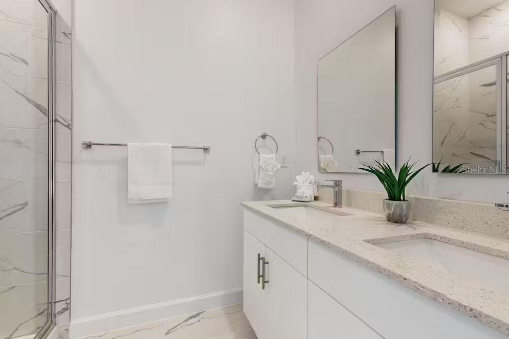 372 Famagusta Drive Davenport, FL 33896 - Photo 18 of 38 a bathroom with a granite countertop sink a mirror and a potted plant