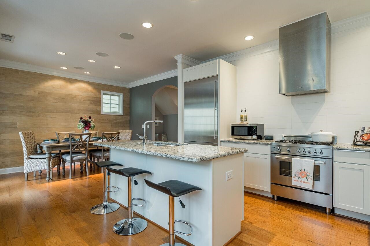 1517 Fullerton Place Raleigh, NC 27607 - Photo 14 of 30 True chef's kitchen w/upgraded white cabinets, granite counters, Gaggenau and Bertazzoni appliances, wine fridge, oversized island. Sleek in design and perfect for use. Kitchen