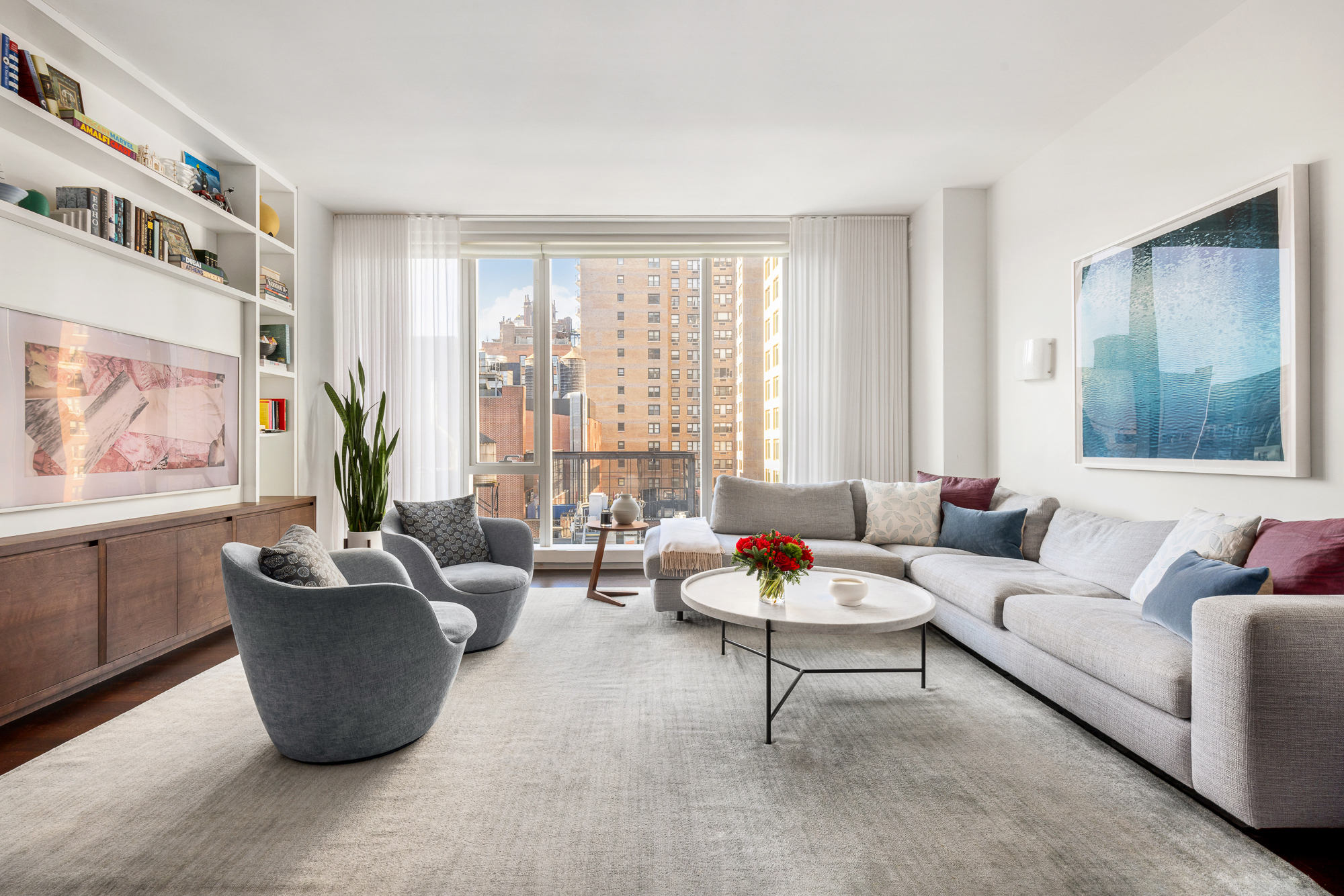 151 East 85th Street, Unit 11C Manhattan, NY 10028 - Photo 1 of 13 a living room with furniture and a large window