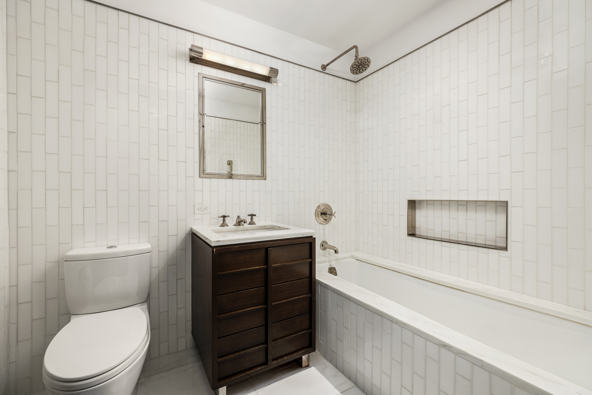 151 East 85th Street, Unit 11C Manhattan, NY 10028 - Photo 10 of 13 a bathroom with a toilet a sink and mirror