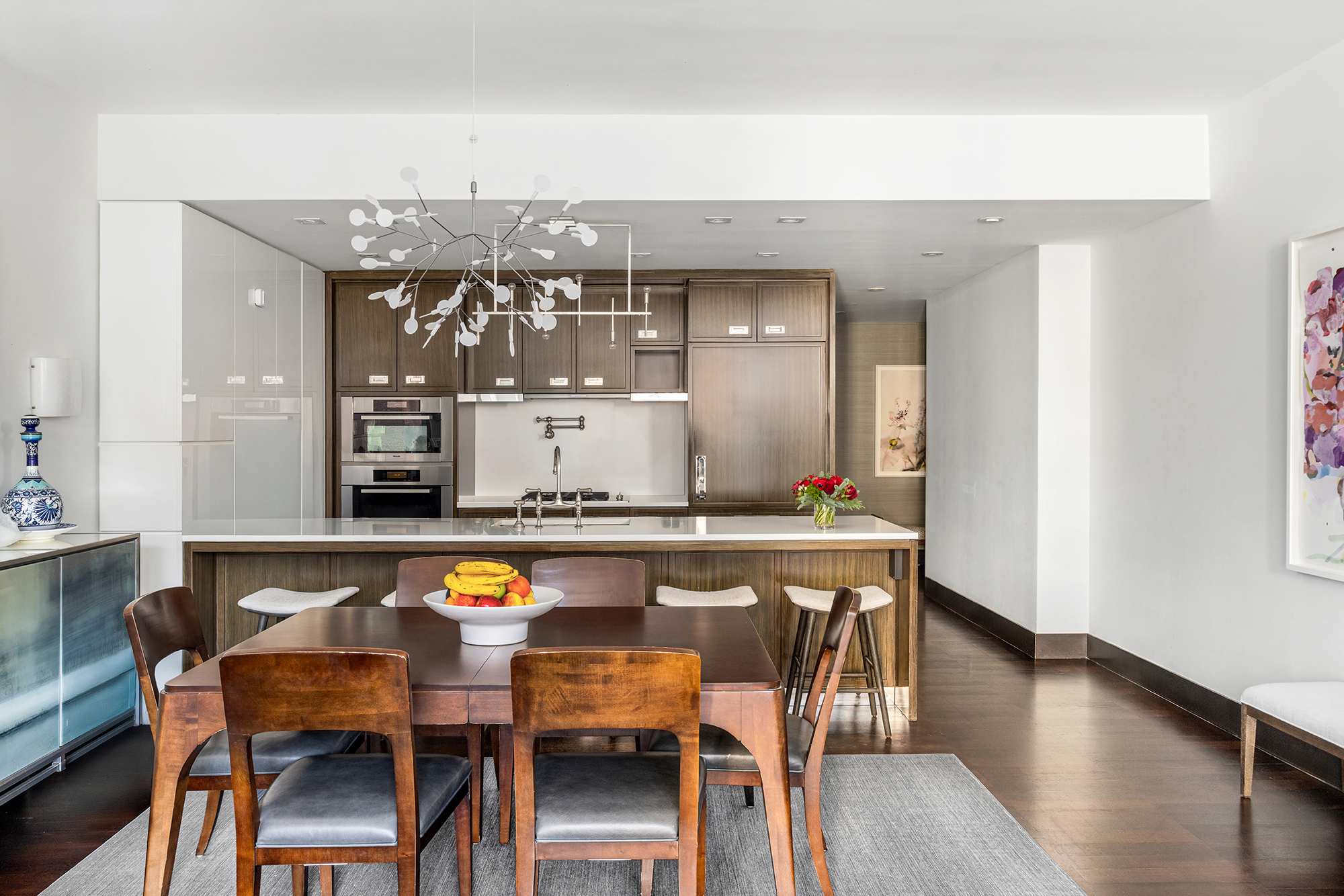 151 East 85th Street, Unit 11C Manhattan, NY 10028 - Photo 4 of 13 a dining hall with stainless steel appliances granite countertop a dining table and chairs with wooden floor