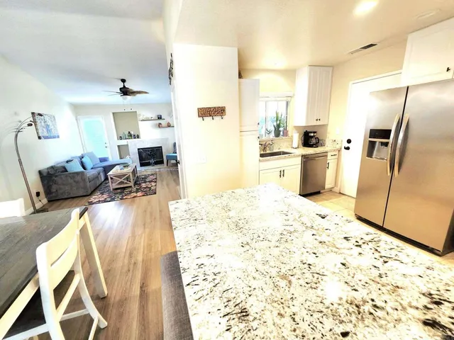 a kitchen with stainless steel appliances kitchen island granite countertop a refrigerator stove top oven and sink