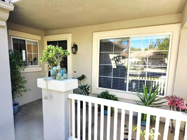 a view of a house with a potted plant and floor to ceiling windows