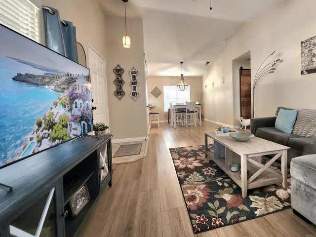 a dining room with wooden floor a chandelier a wooden table and chairs