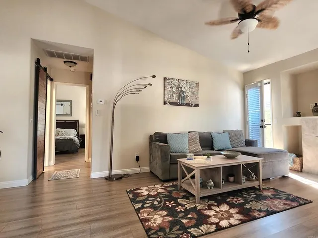 a large open kitchen with stainless steel appliances kitchen island granite countertop a stove a refrigerator a sink a dining table and chairs with wooden floor