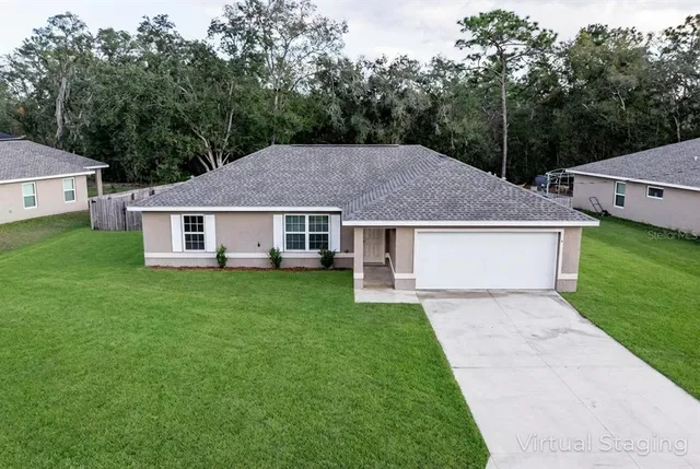 a aerial view of a house next to a yard and trees