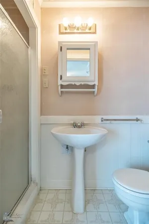 a bathroom with a sink a toilet and mirror