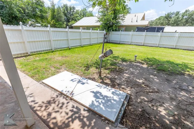 a view of a backyard with a swimming pool and sitting area