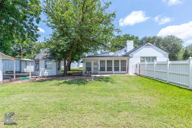 a view of a house with a big yard and large trees