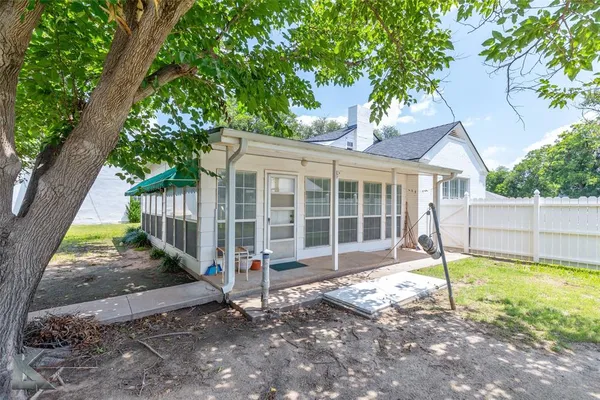 a view of a house with backyard and a tree
