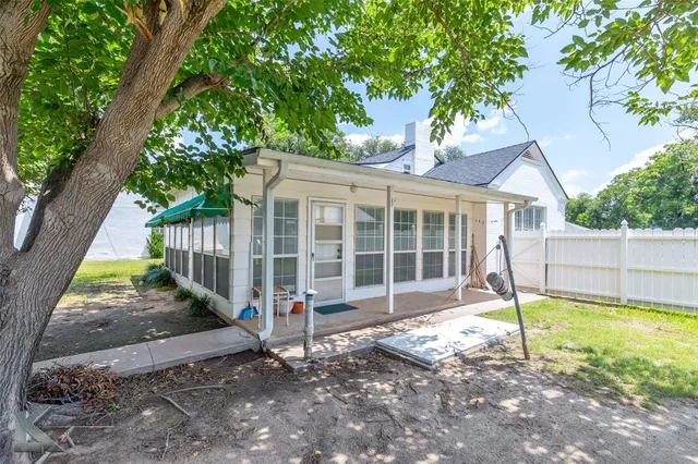 a view of a house with backyard and a tree