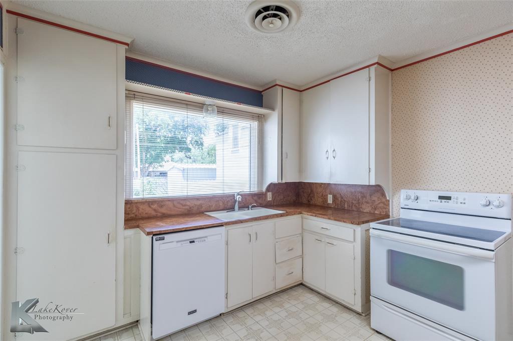 907 North Ave G Haskell, TX 79521 - Photo 7 of 40 a utility room with cabinets washer and dryer
