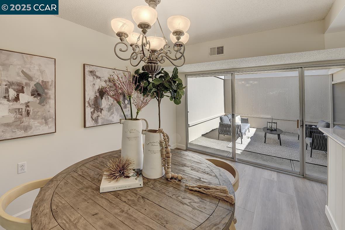 2041 Golden Rain Road, Unit 4 Walnut Creek, CA 94595 - Photo 11 of 53 a dining room with wooden floor a chandelier a glass table and chairs