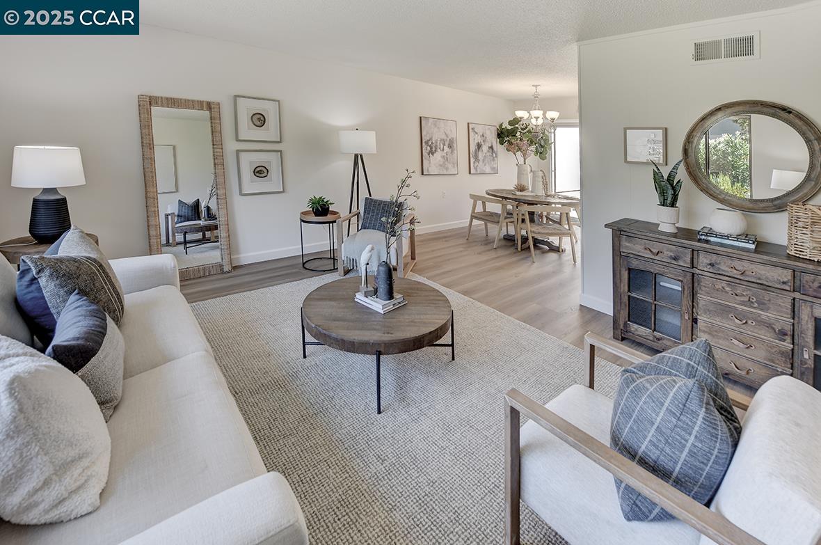 2041 Golden Rain Road, Unit 4 Walnut Creek, CA 94595 - Photo 8 of 53 a living room with furniture a mirror and a clock