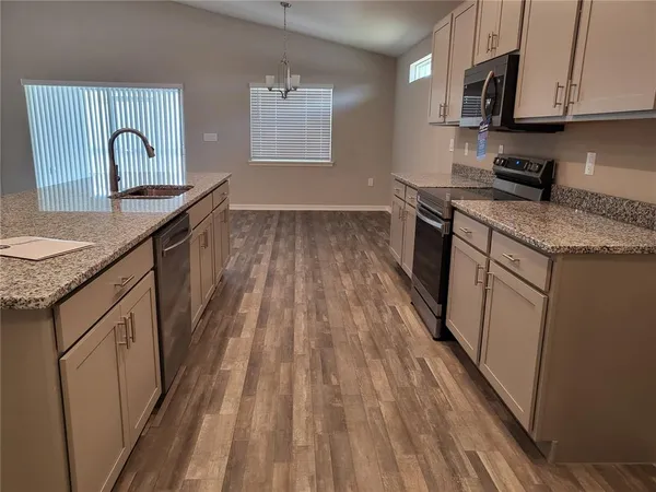 a kitchen with stainless steel appliances granite countertop wooden cabinets a sink and a stove