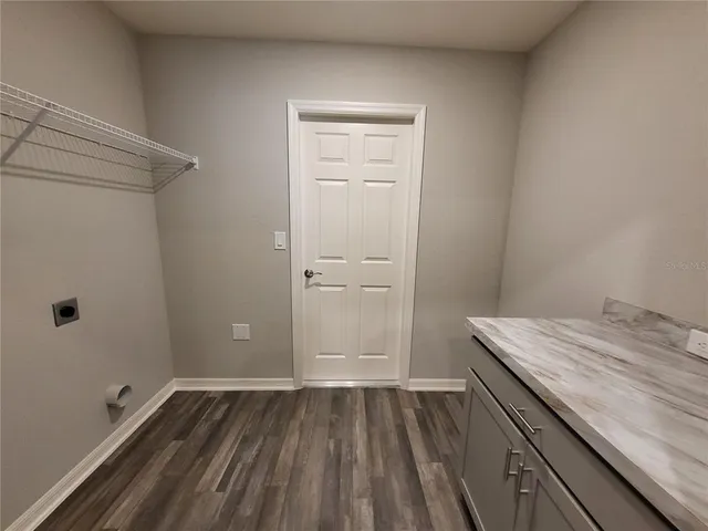 a view of an empty room with closet and a window