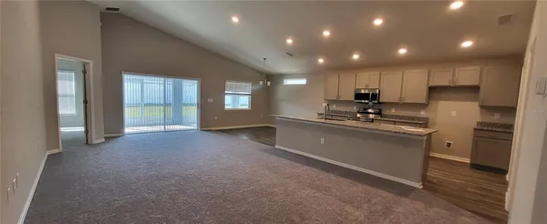 a kitchen with kitchen island granite countertop stainless steel appliances and white cabinets