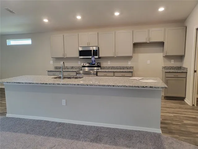a kitchen with sink a microwave a stove and refrigerator