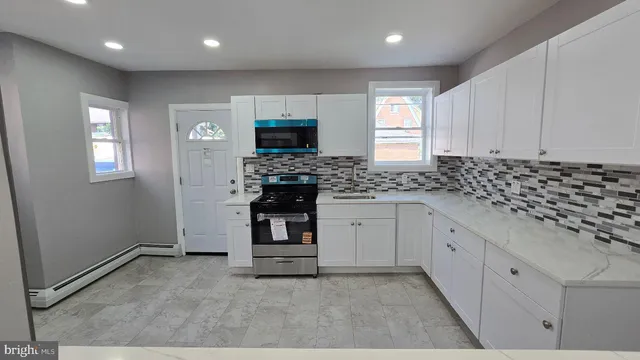 a view of kitchen with stainless steel appliances granite countertop cabinets and door