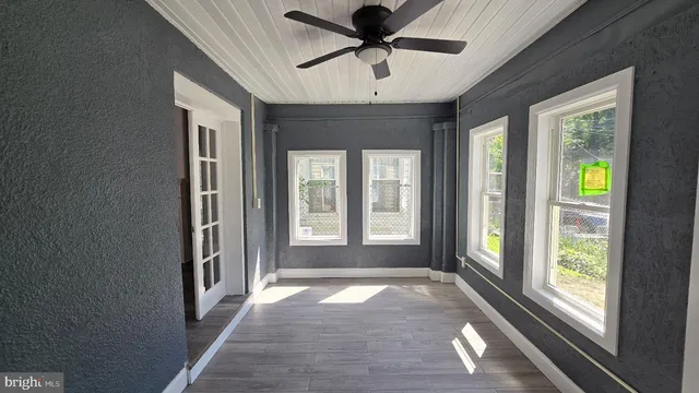 a view of empty room with wooden floor and fireplace