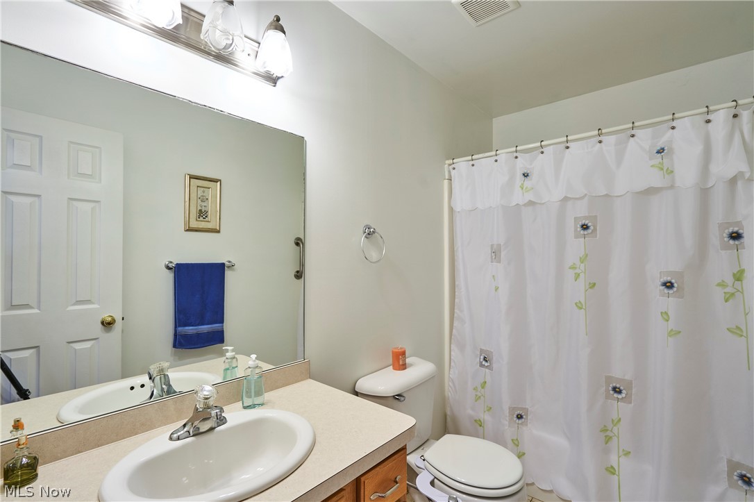 1963 Haines Road Madison, OH 44057 - Photo 18 of 34 Bathroom featuring a vanity with a laminate countertop, an undermount sink, and a large wall-mounted mirror