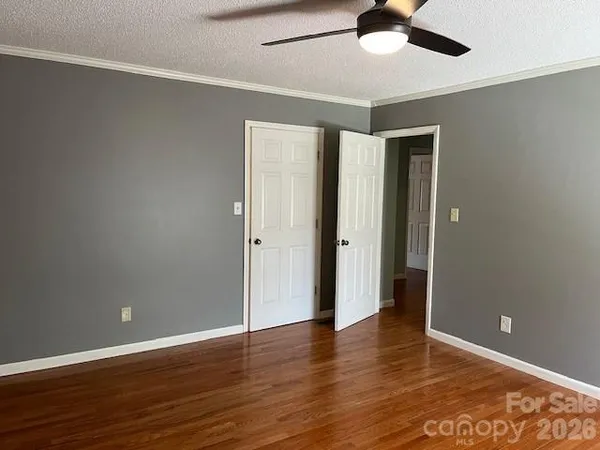 a view of a hallway with wooden floor and staircase