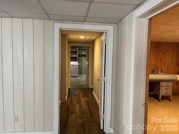 an empty room with wooden floor a ceiling fan and windows