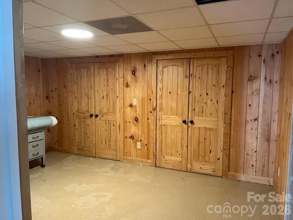 an empty room with wooden floor fireplace and windows
