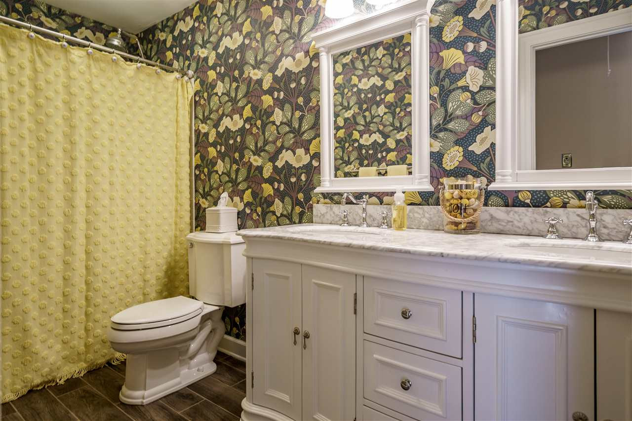 1028 Mersey Lane Raleigh, NC 27615 - Photo 21 of 30 Hall Bathroom with white cabinets, custom pulls, granite tops, paired mirrors, tub/shower with Rohl fixtures and tile floors. Bathroom