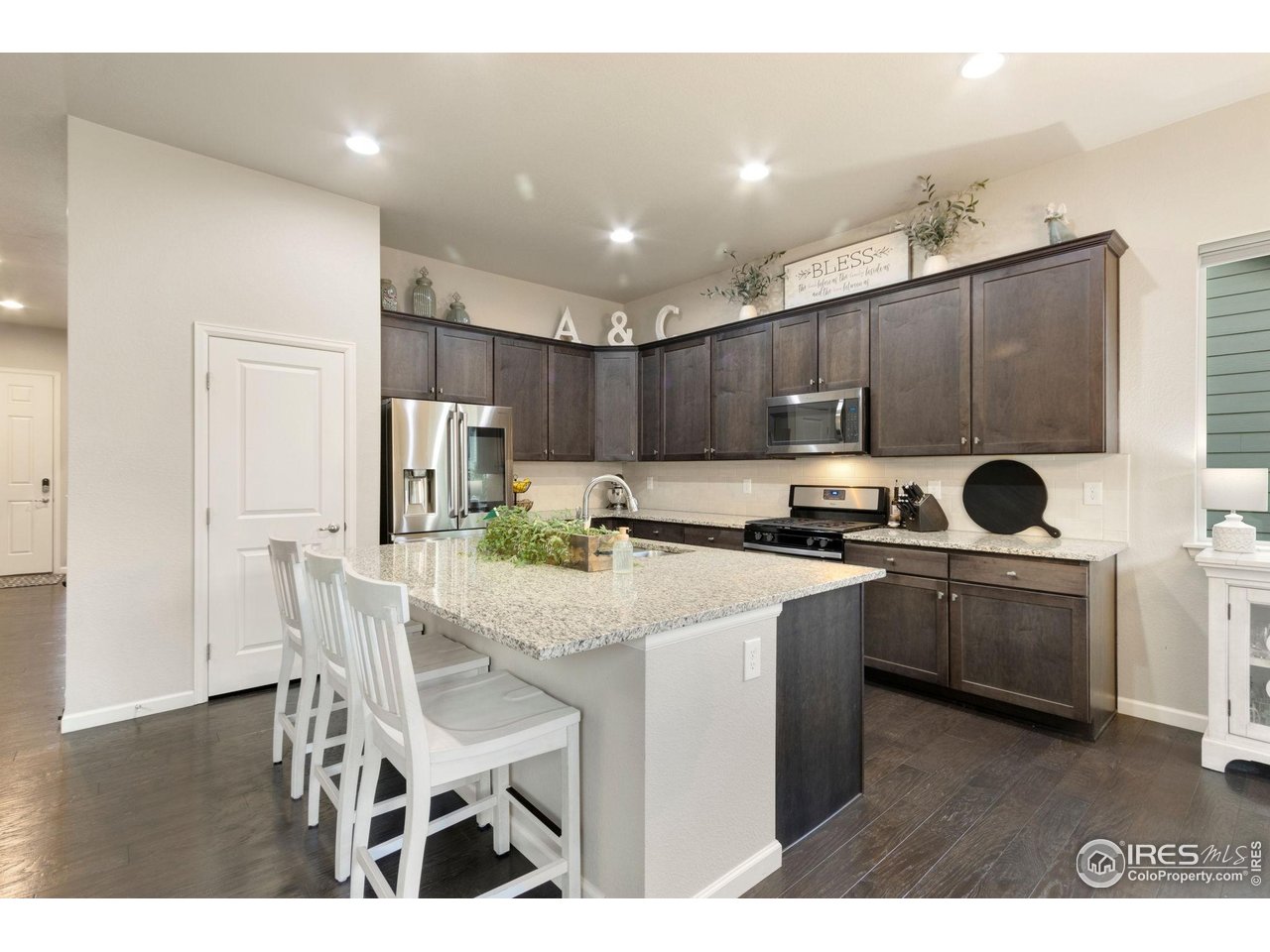 719 Wagon Bend Road Berthoud, CO 80513 - Photo 4 of 40 a kitchen with cabinets a sink stainless steel appliances and dining table