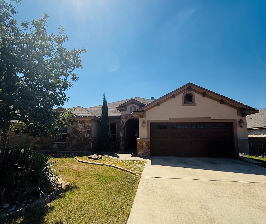 a front view of a house with a yard and garage