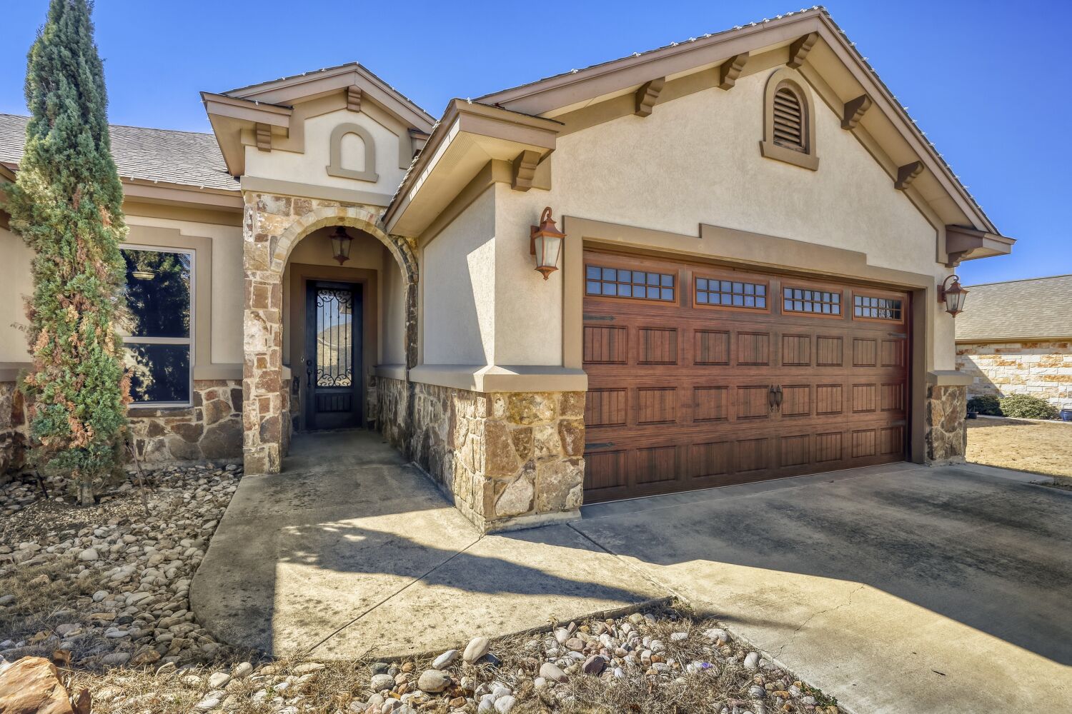 329 Jake Drive Jarrell, TX 76537 - Photo 2 of 17 Mediterranean / spanish-style home with stone siding, concrete driveway, stucco siding, and an attached garage