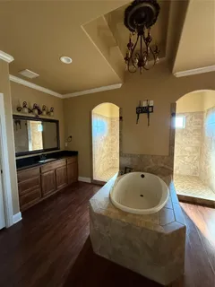 a bathroom with a tub sink and mirror