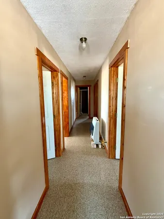 a view of a hallway with furniture and a window