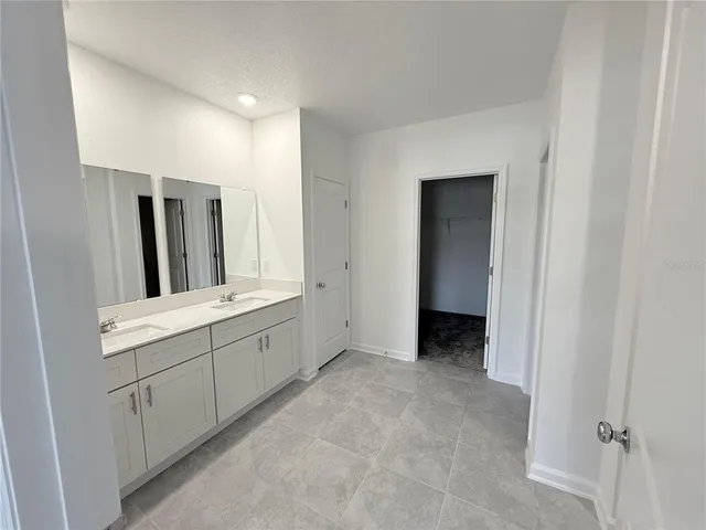 a bathroom with a double vanity sink and mirror