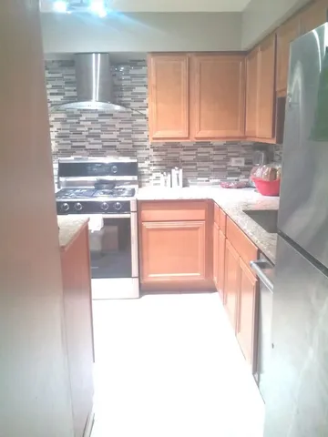 a kitchen with granite countertop a refrigerator and a stove