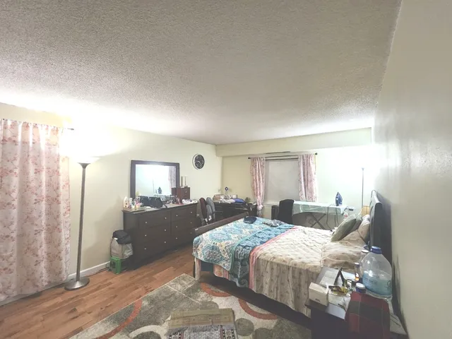 a bedroom with a bed and wooden floor