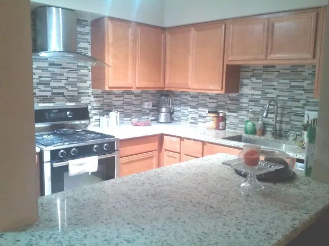 a kitchen with stainless steel appliances granite countertop a sink stove and cabinets