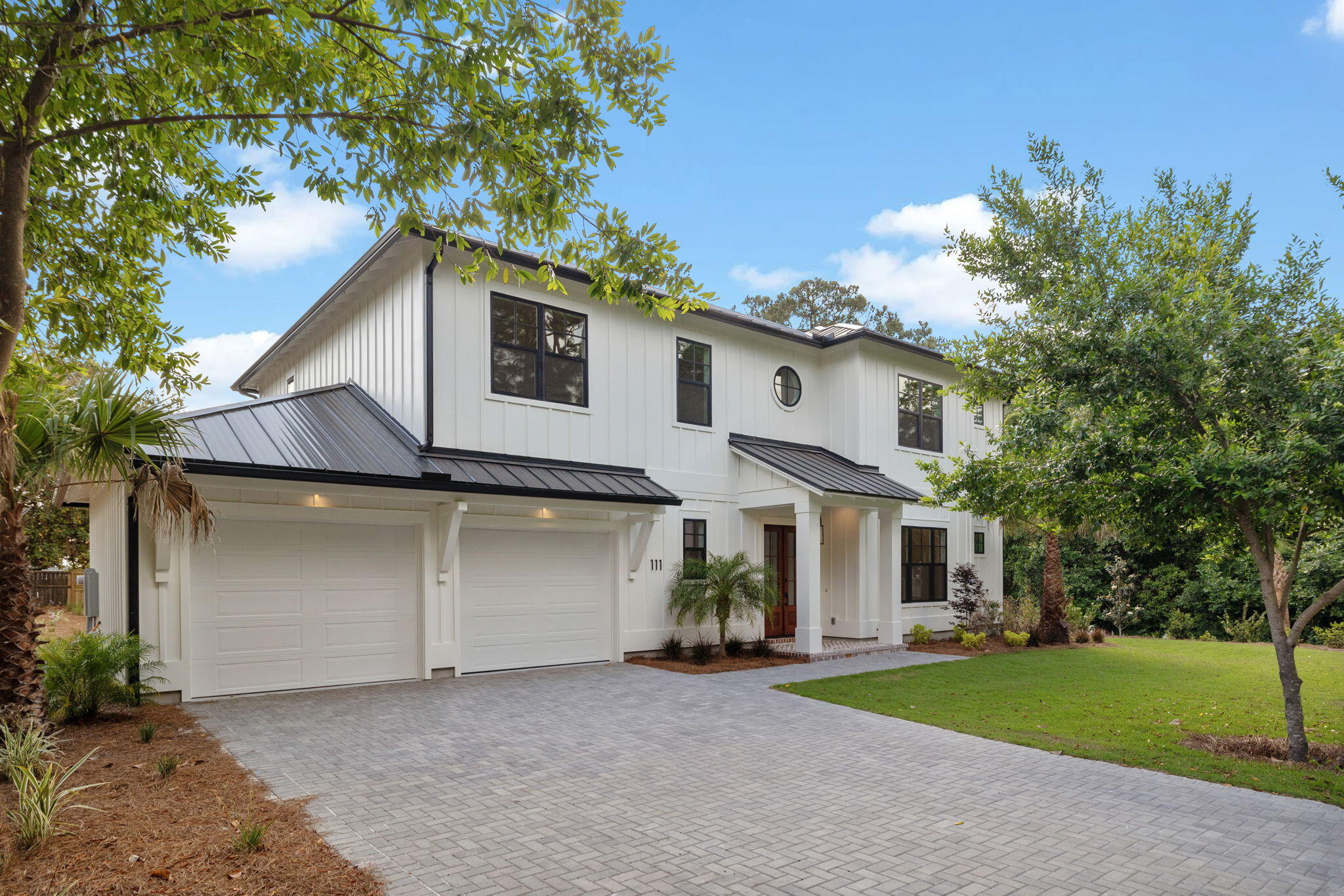 a view of a house with a yard and large tree