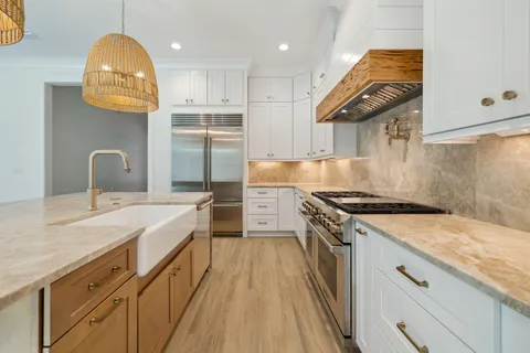 a view of an empty room with wooden floor and a fireplace