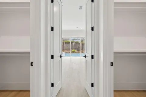 a view of a hallway with wooden floor