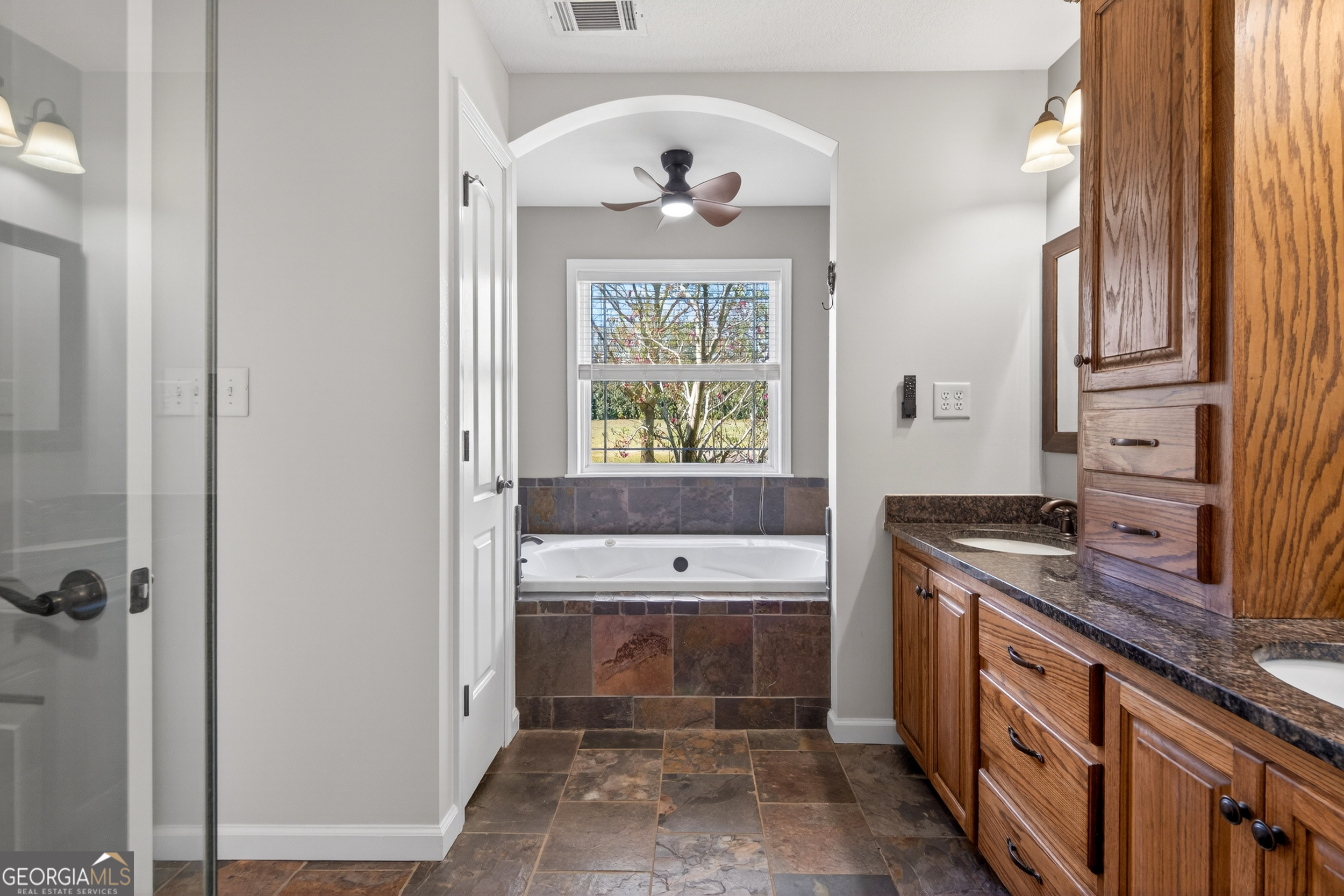 1211 Parham Town Road Bowman, GA 30624 - Photo 18 of 86 a bathroom with a double vanity sink a mirror and a bathtub