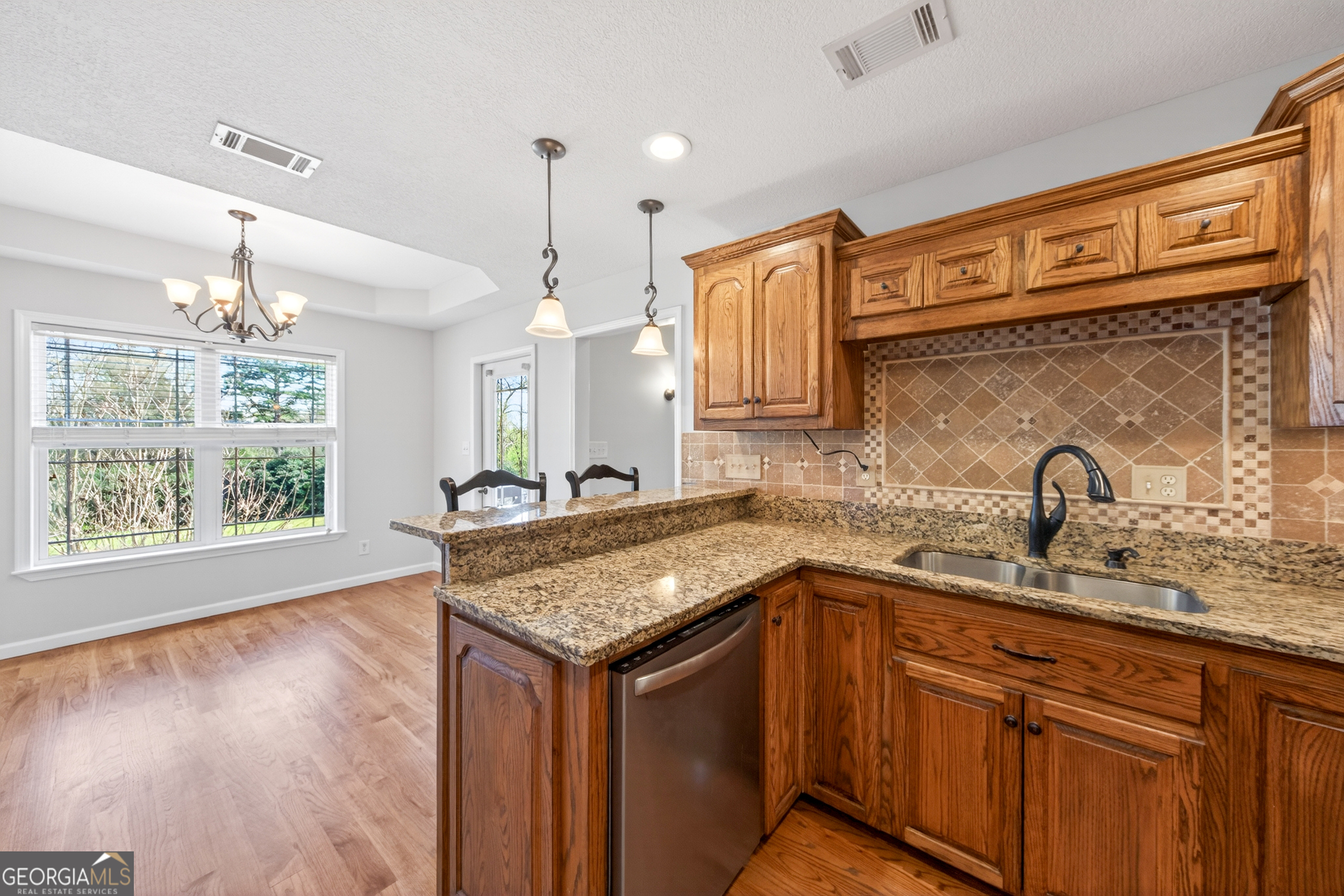 1211 Parham Town Road Bowman, GA 30624 - Photo 28 of 86 a kitchen with stainless steel appliances granite countertop a sink a stove a kitchen island with wooden cabinets and floor